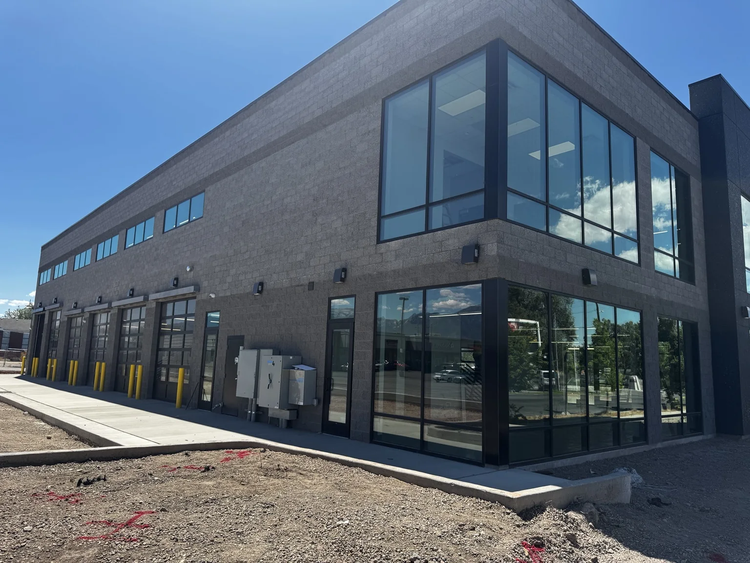 Side exterior of the Big O Tire building with a two-story glass showroom and dark architectural accents