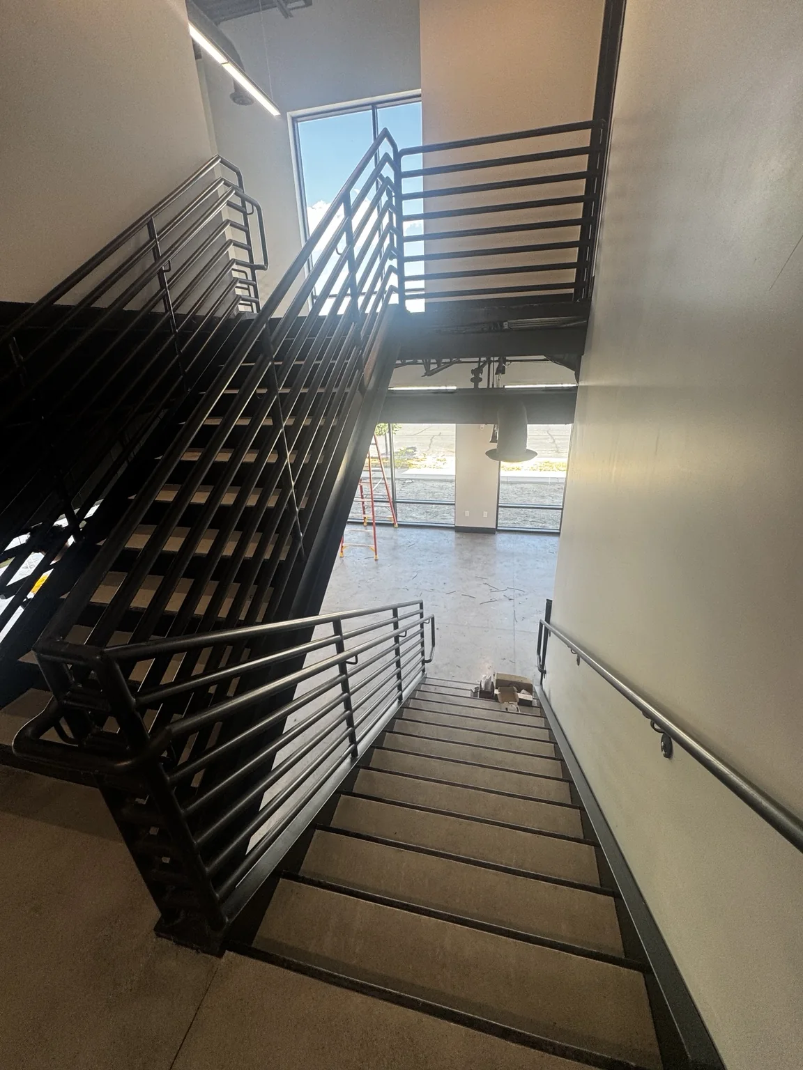 Big O Tire interior stairway with black painted steel railings and finished stair treads